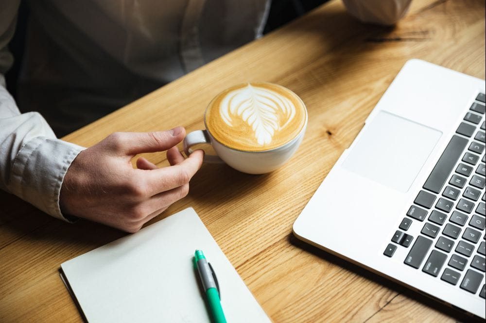 Man with a cup of coffee by table